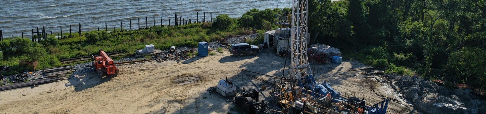 Double case reverse rotary drill rig on a waterfront water well site